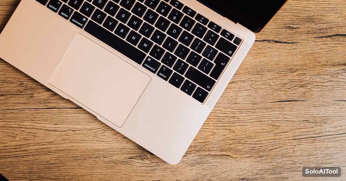 Overhead view of a silver laptop on a light oak wooden desk